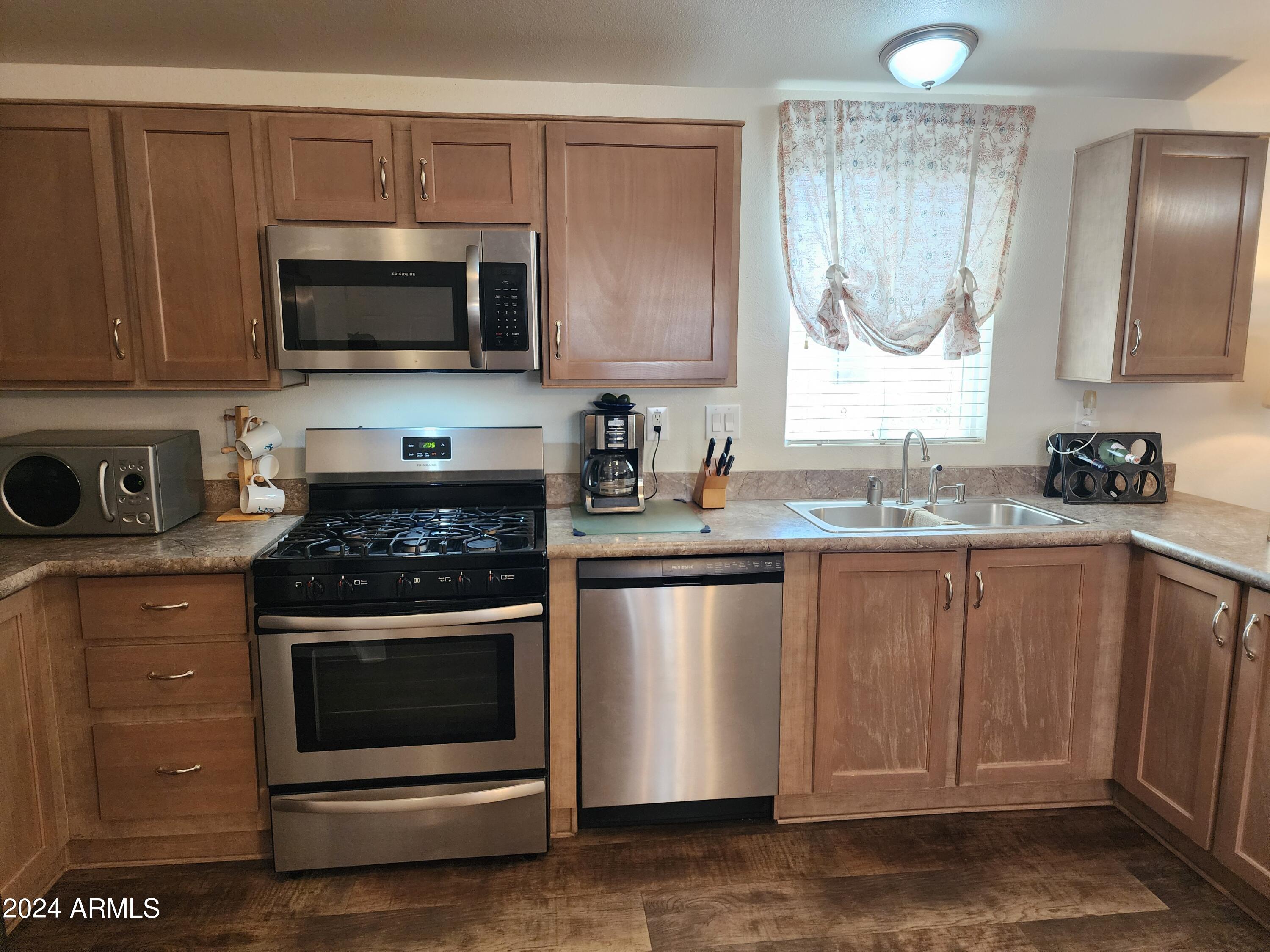 16005 North 32nd Street, Unit 31 Phoenix, AZ 85032 - Photo 15 of 48 a kitchen with stainless steel appliances a stove a sink and a microwave