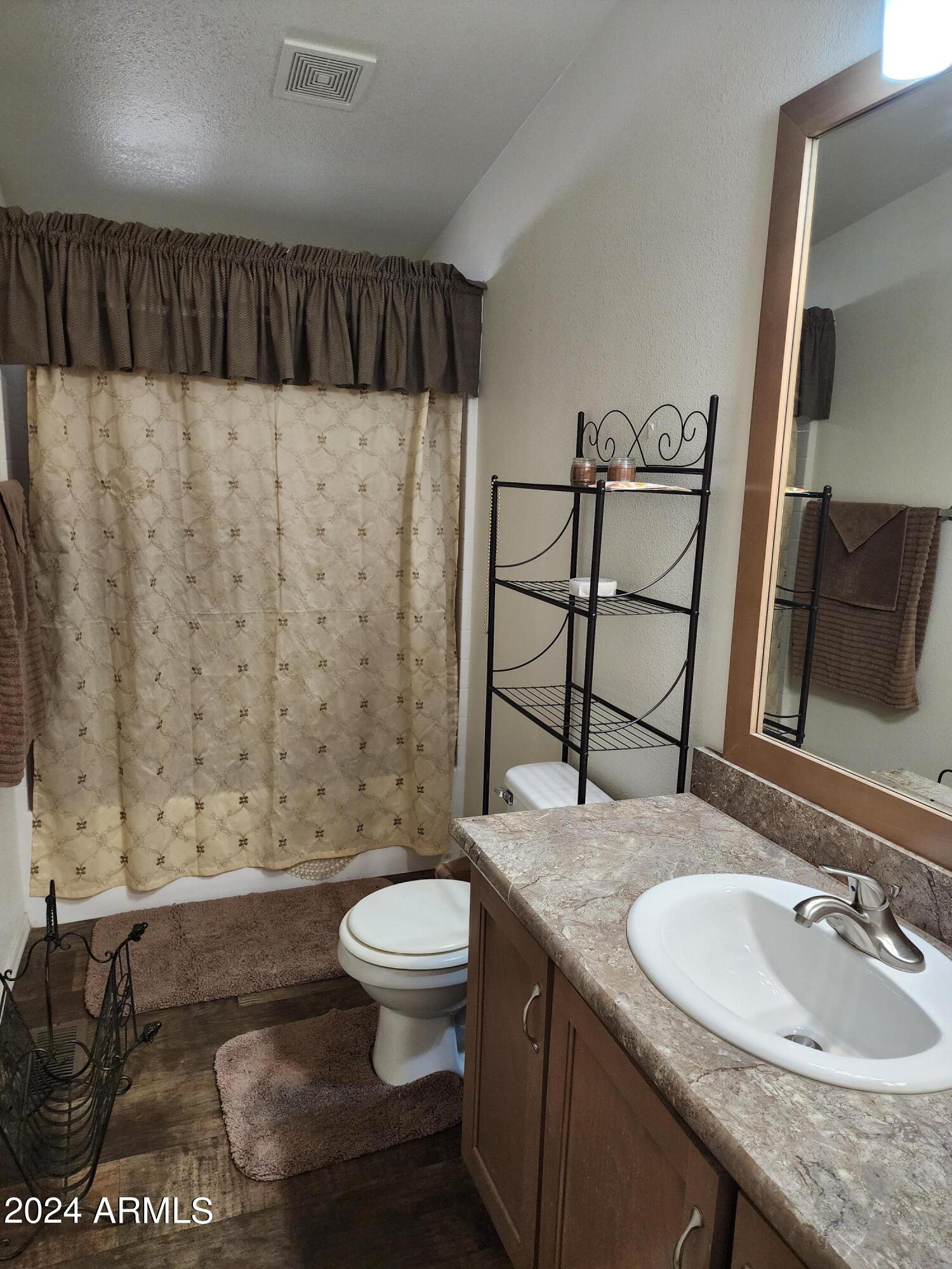 16005 North 32nd Street, Unit 31 Phoenix, AZ 85032 - Photo 28 of 48 a bathroom with a granite countertop sink a toilet and a mirror
