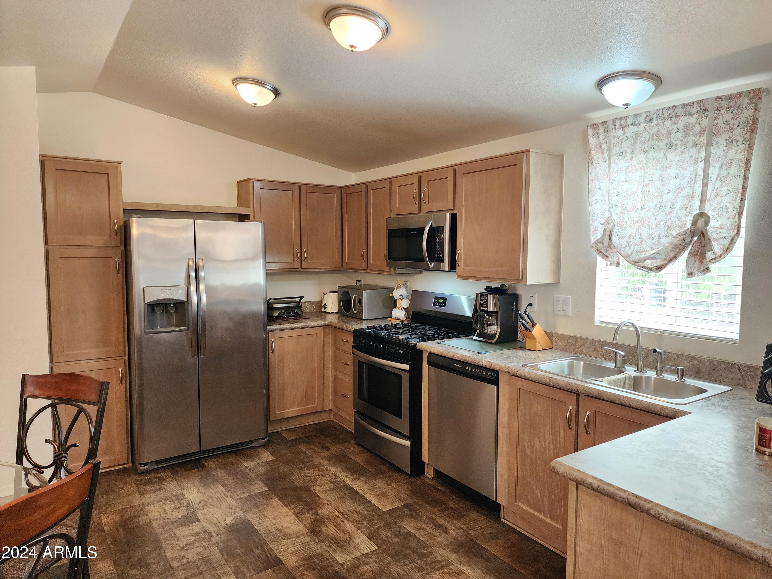 16005 North 32nd Street, Unit 31 Phoenix, AZ 85032 - Photo 5 of 48 a kitchen with stainless steel appliances granite countertop a sink a stove a refrigerator cabinets and a dining table
