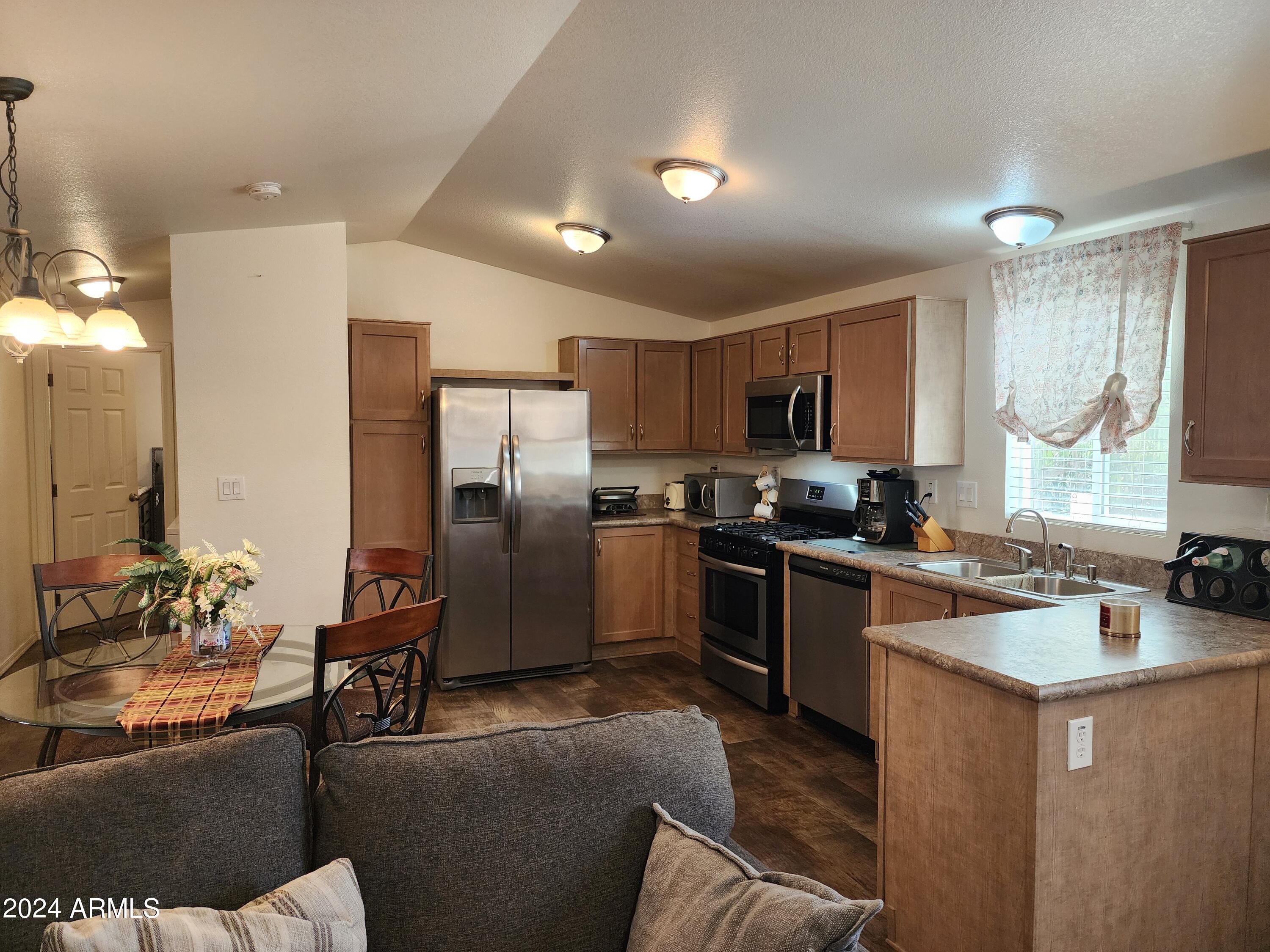 16005 North 32nd Street, Unit 31 Phoenix, AZ 85032 - Photo 6 of 48 a kitchen with stainless steel appliances granite countertop a refrigerator a sink a stove a dining table and chairs