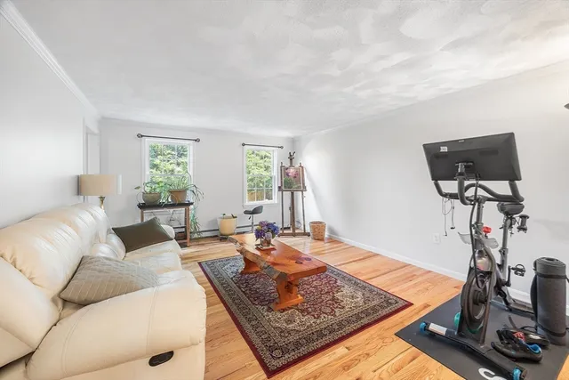a bedroom with a bed and dresser with wooden floor