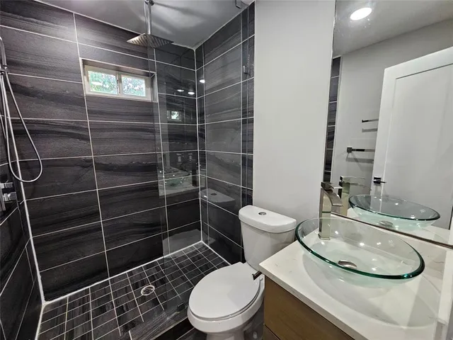 a bathroom with a toilet a sink and shower
