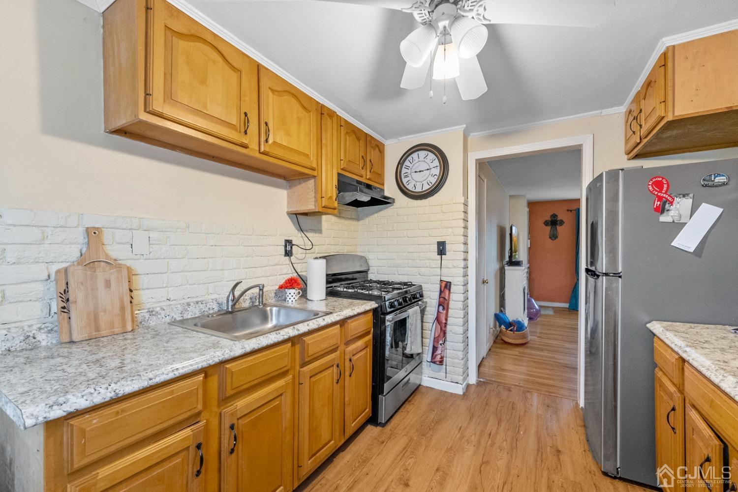 22B Garfield Park, Unit A Edison, NJ 08837 - Photo 13 of 36 a kitchen with cabinets a stove and a wooden floor