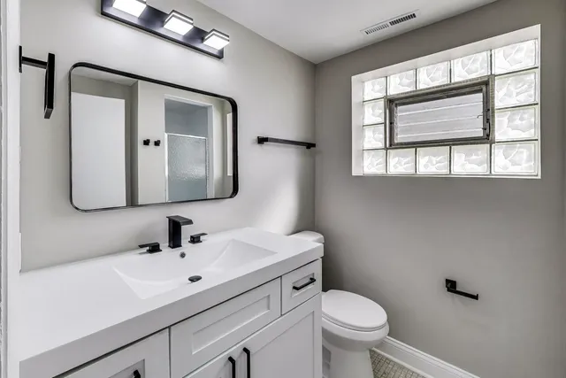 a bathroom with a toilet sink and mirror