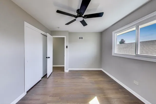 a view of empty room with wooden floor