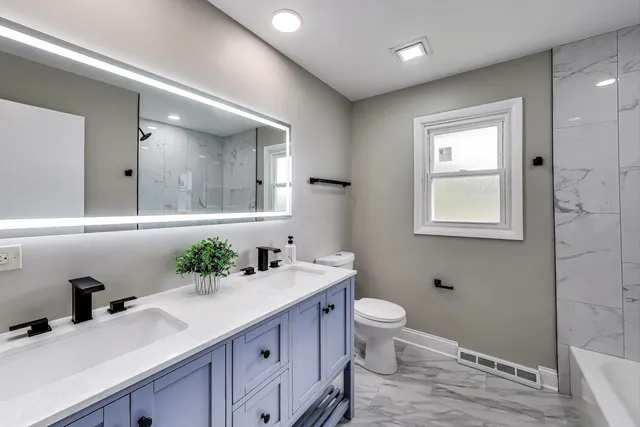 a bathroom with a granite countertop sink a toilet and a mirror