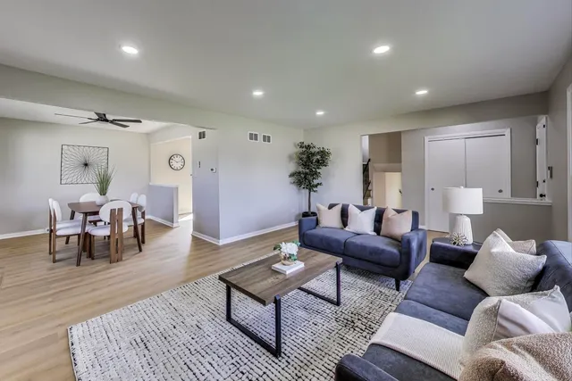 a living room with furniture and wooden floor