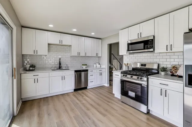 a kitchen with stainless steel appliances granite countertop a stove sink and cabinets