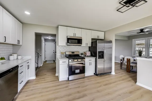 a kitchen with stainless steel appliances a stove top oven a refrigerator a sink and dishwasher