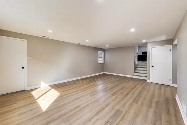 a view of empty room with wooden floor and window