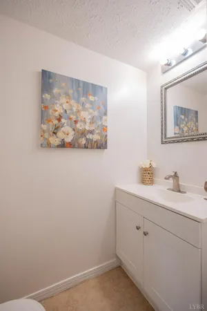 a view of bathroom with a sink and a painting on the wall