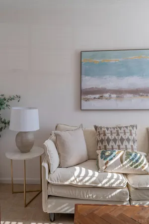 a living room with furniture and a painting on the wall