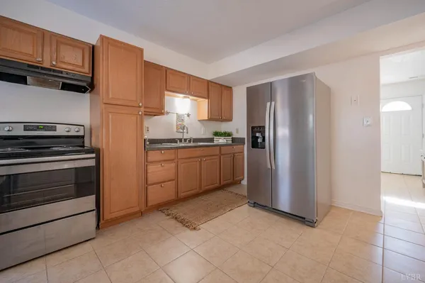 a kitchen with a refrigerator sink and cabinets