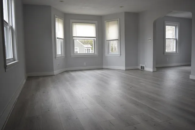 a view of an empty room with wooden floor