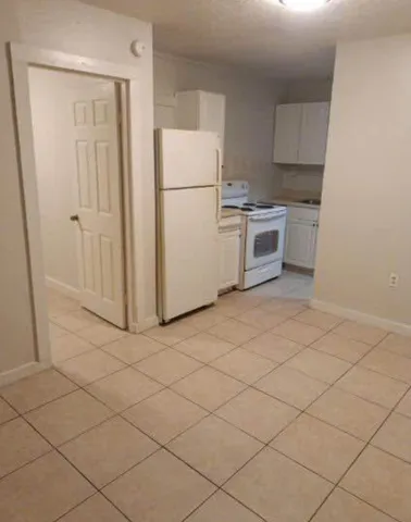 a kitchen with white cabinets and white appliances