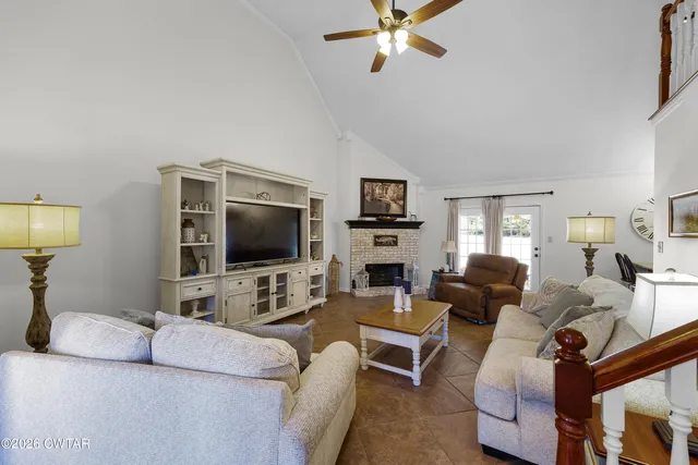 a living room with furniture a fireplace and a flat screen tv