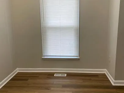 a view of a small space with wooden floor and a window
