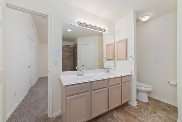 a spacious bathroom with a toilet sink and mirror