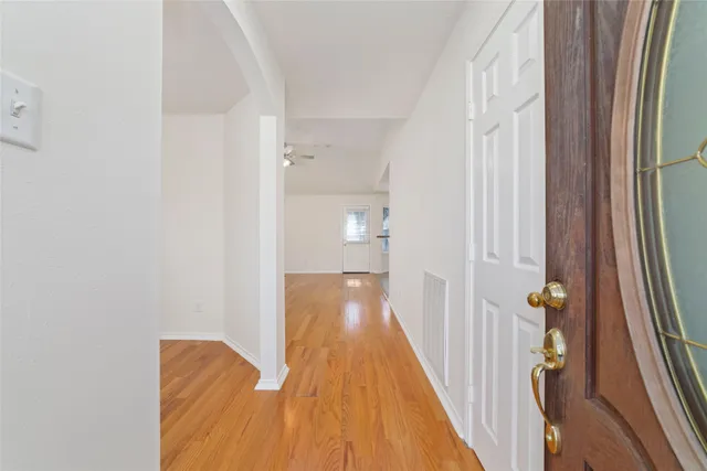 a view of a hallway with wooden floor and staircase