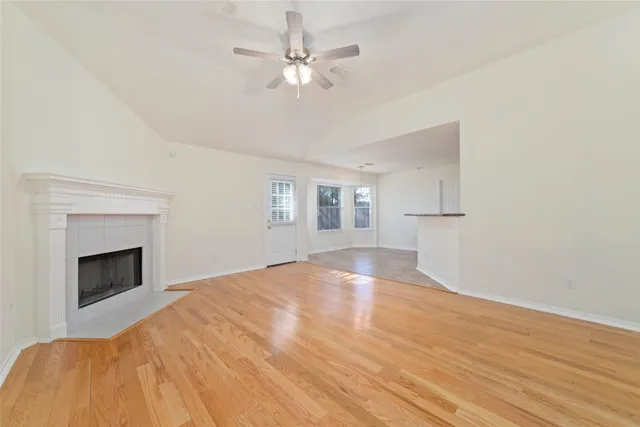 a view of empty room with a fireplace and wooden floor