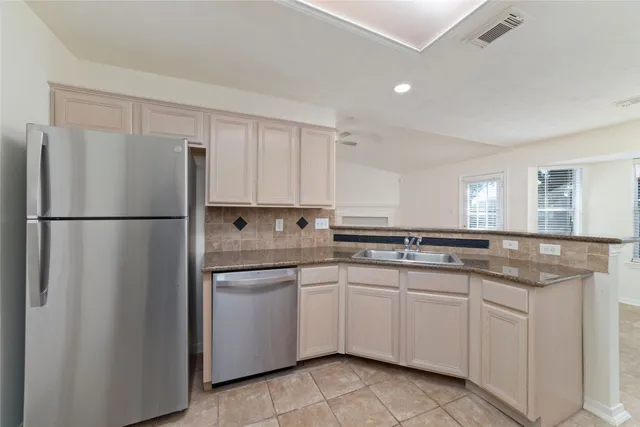 a kitchen with white cabinets and sink