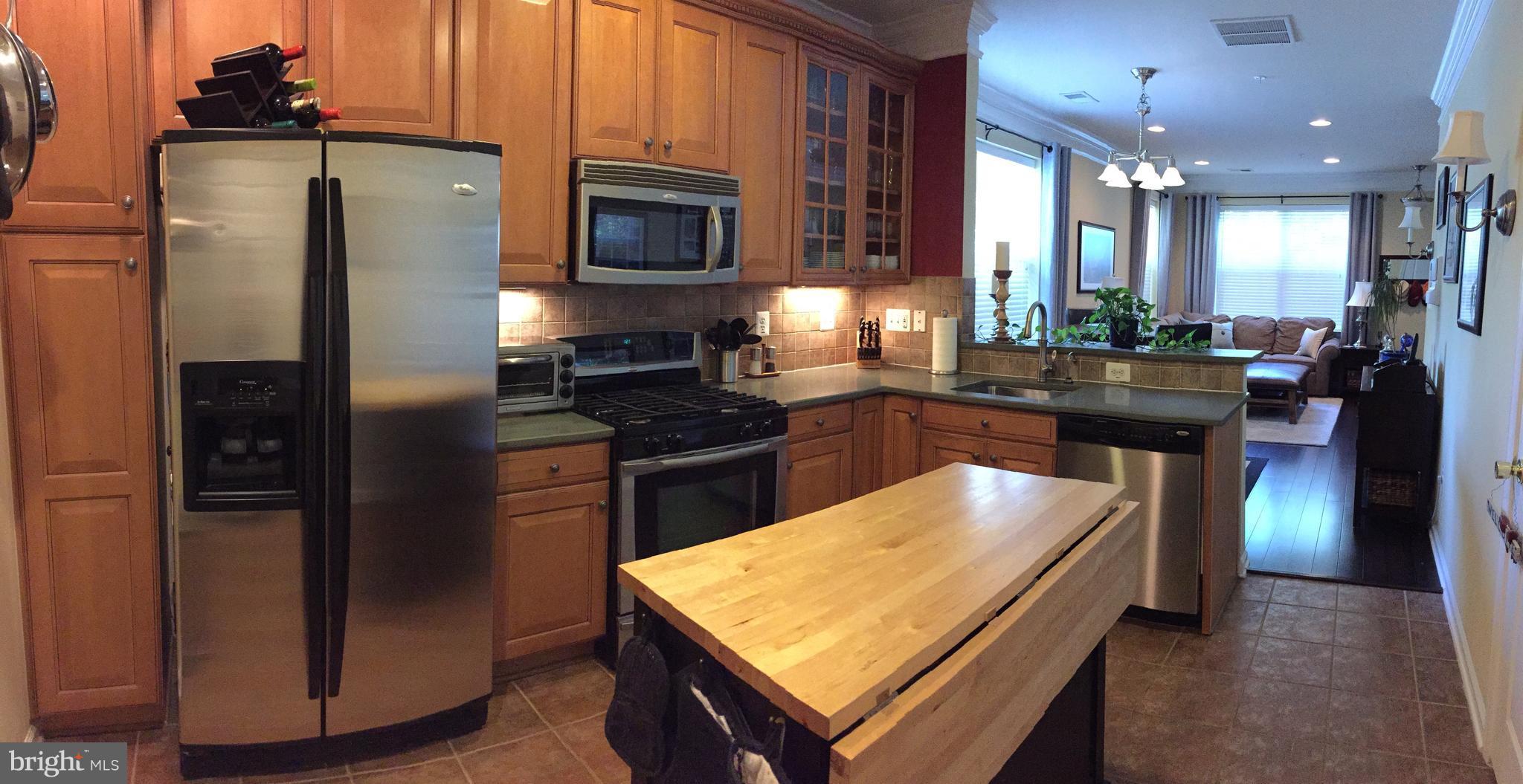 12432 Liberty Bridge Road, Unit A Fairfax, VA 22033 - Photo 5 of 14 a kitchen with stainless steel appliances granite countertop a refrigerator a stove top oven and a sink