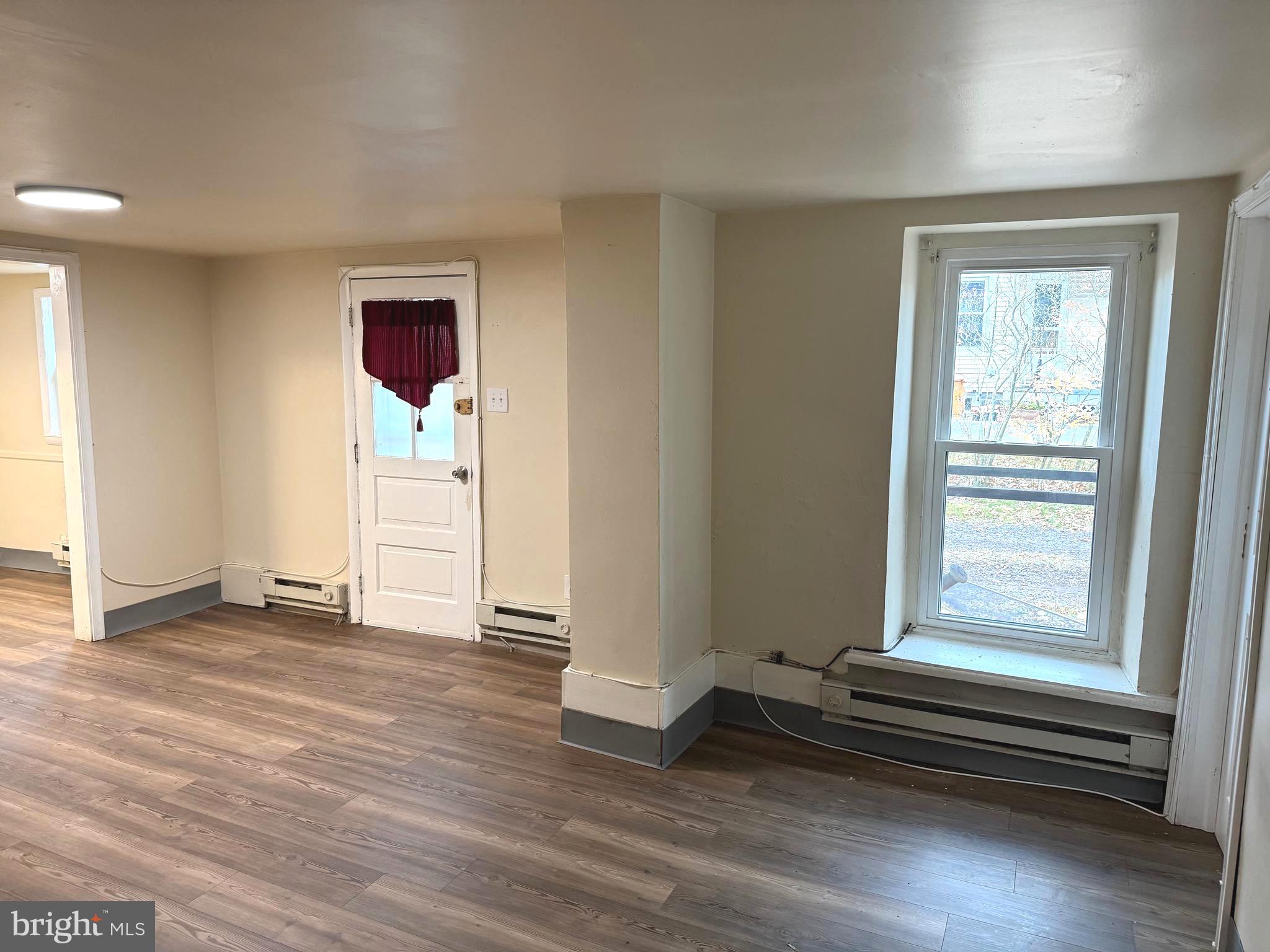 725 West Broad Street, Unit 4 Quakertown, PA 18951 - Photo 2 of 14 an empty room with wooden floor and windows