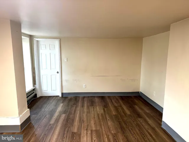 a view of a room with wooden floor and a window