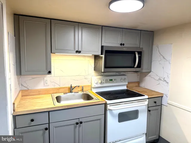 a kitchen with stainless steel appliances a stove a sink and a microwave