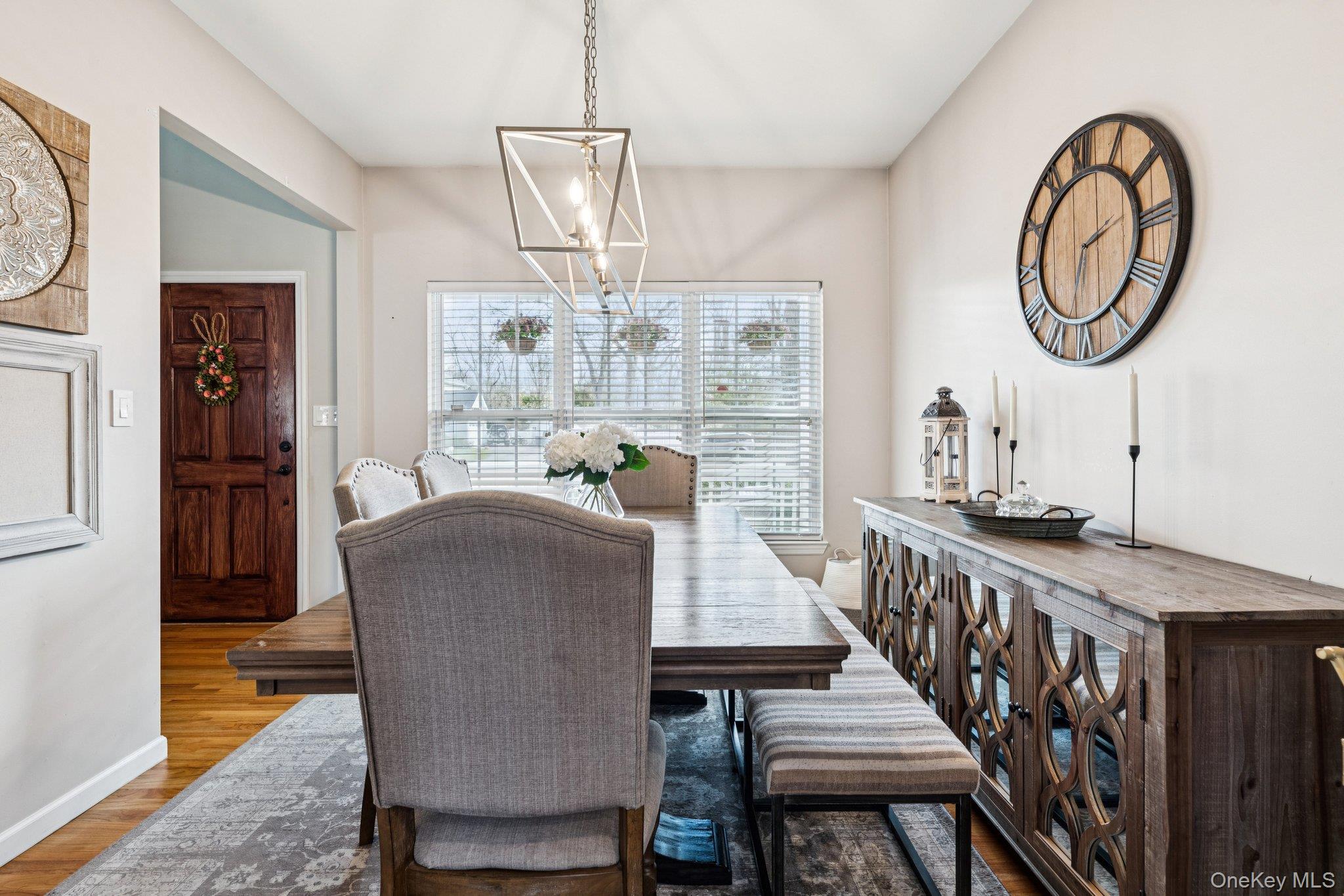 4 Clinton Avenue Bellport, NY 11713 - Photo 12 of 34 a dining room with wooden floor a chandelier a wooden table and chairs