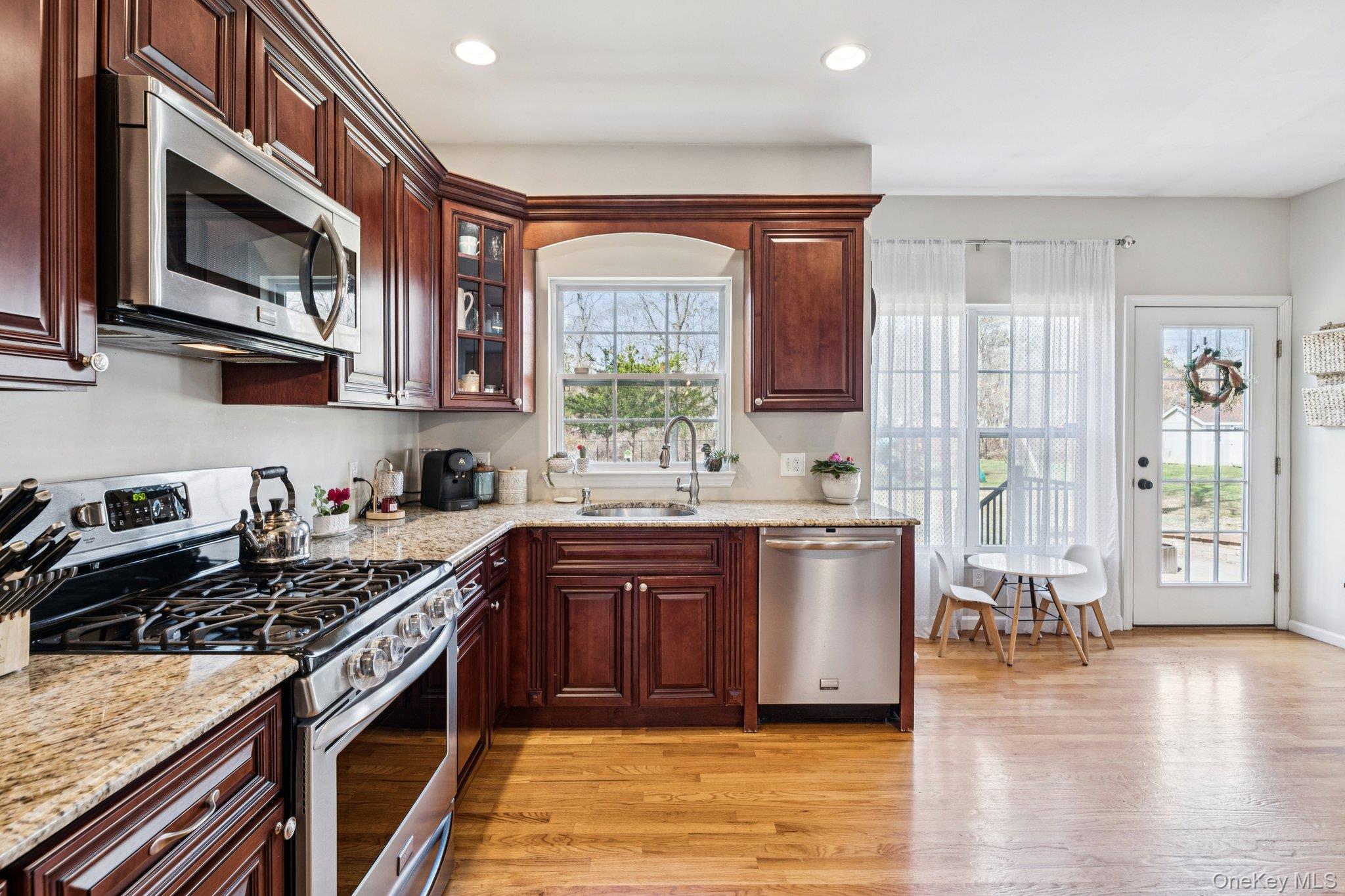 4 Clinton Avenue Bellport, NY 11713 - Photo 13 of 34 a kitchen with a stove a sink and a microwave