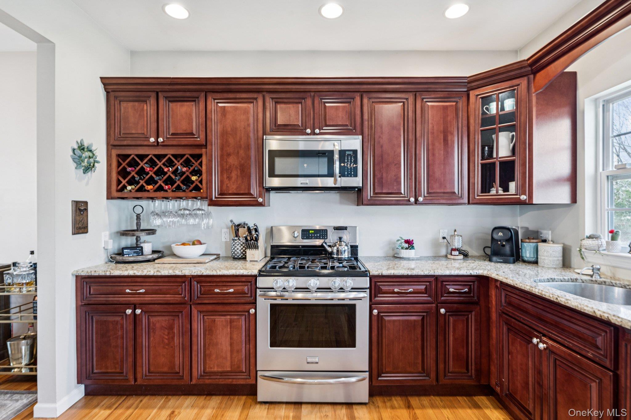 4 Clinton Avenue Bellport, NY 11713 - Photo 14 of 34 a kitchen with stainless steel appliances wooden cabinets and a stove top oven