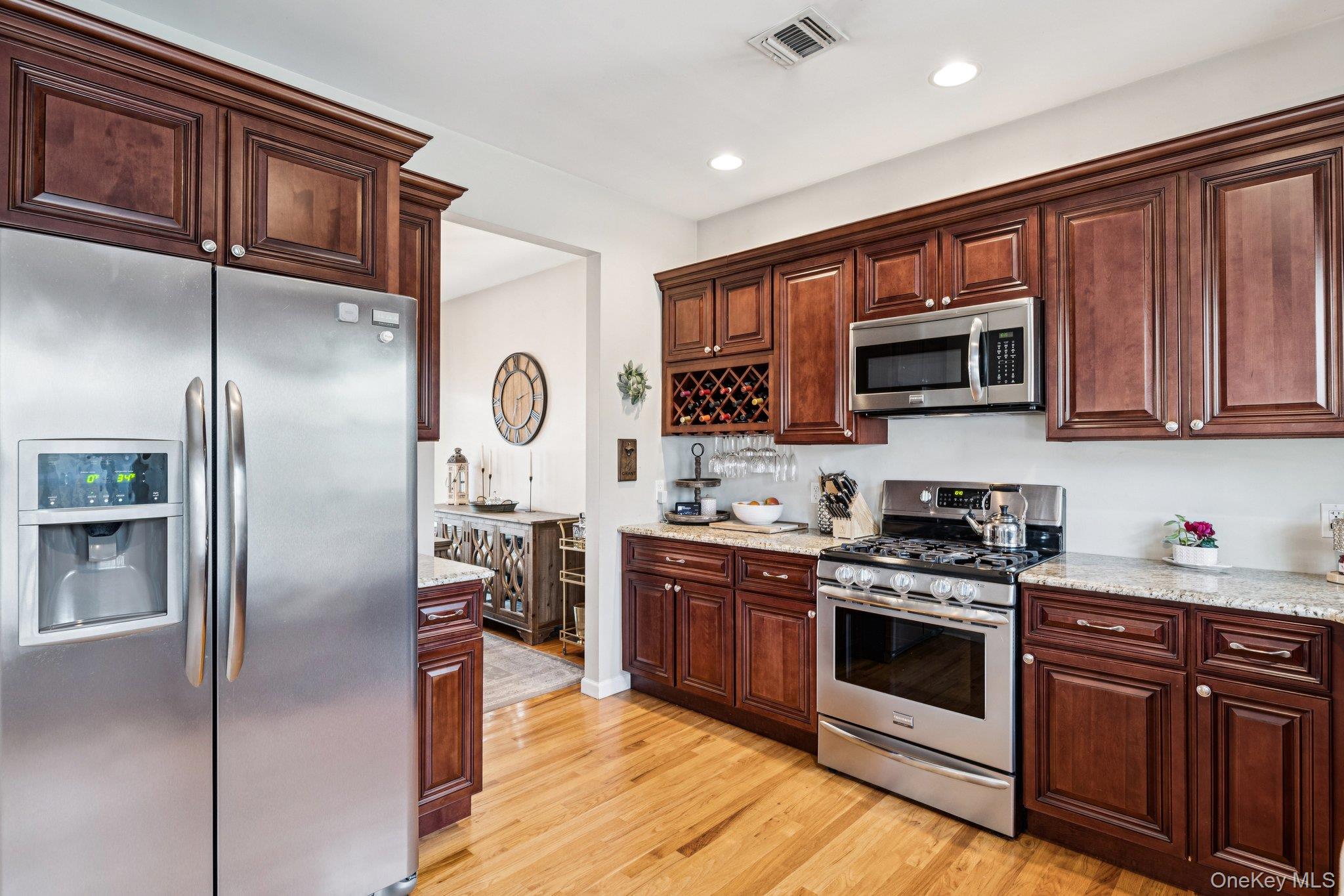 4 Clinton Avenue Bellport, NY 11713 - Photo 15 of 34 a kitchen with stainless steel appliances granite countertop a stove top oven a refrigerator and a microwave