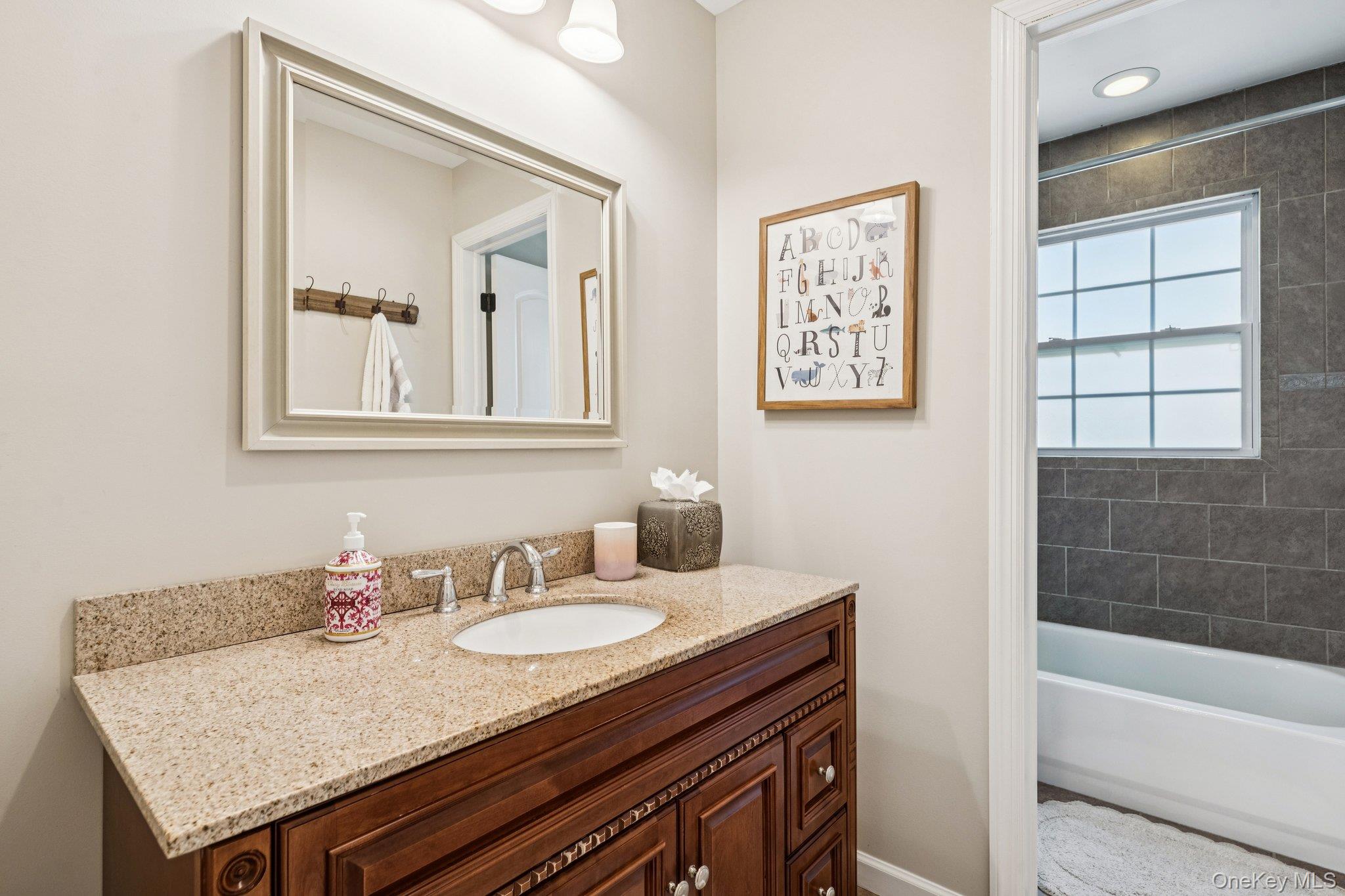 4 Clinton Avenue Bellport, NY 11713 - Photo 23 of 34 a bathroom with a granite countertop sink and a bathtub