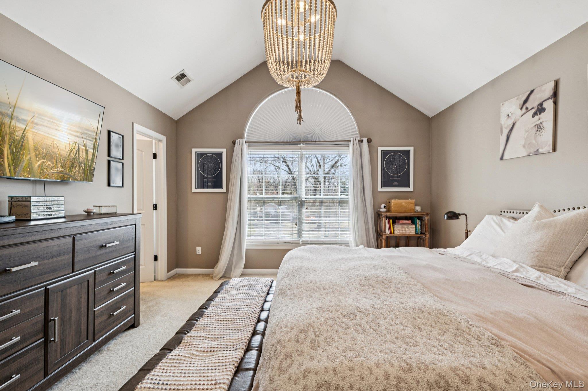 4 Clinton Avenue Bellport, NY 11713 - Photo 24 of 34 a bedroom with a large bed and a chandelier