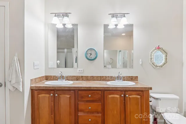 a bathroom with a granite countertop sink a toilet and a mirror
