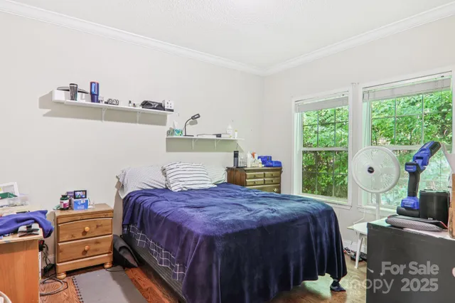 a bed sitting in a bedroom next to a window