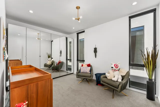 a view of a patio with couches table and chairs under an umbrella