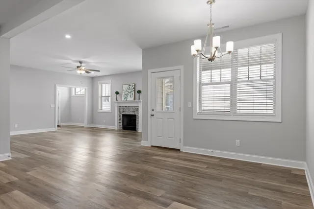 a view of empty room with wooden floor and fireplace