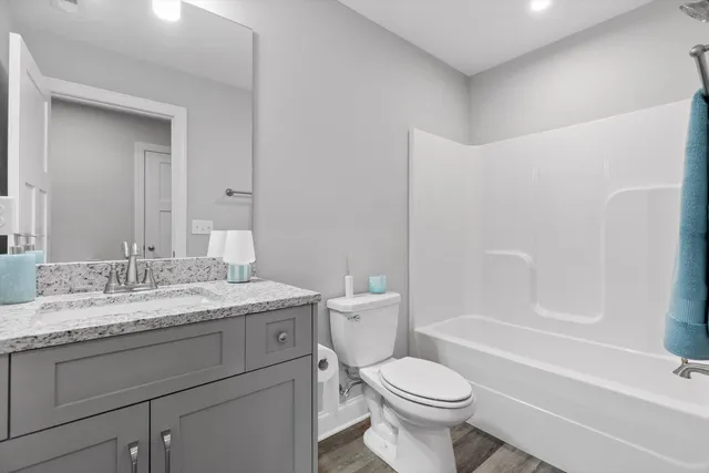 a bathroom with a granite countertop toilet a sink and a bathtub