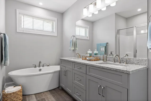 a bathroom with a granite countertop sink mirror and a bathtub