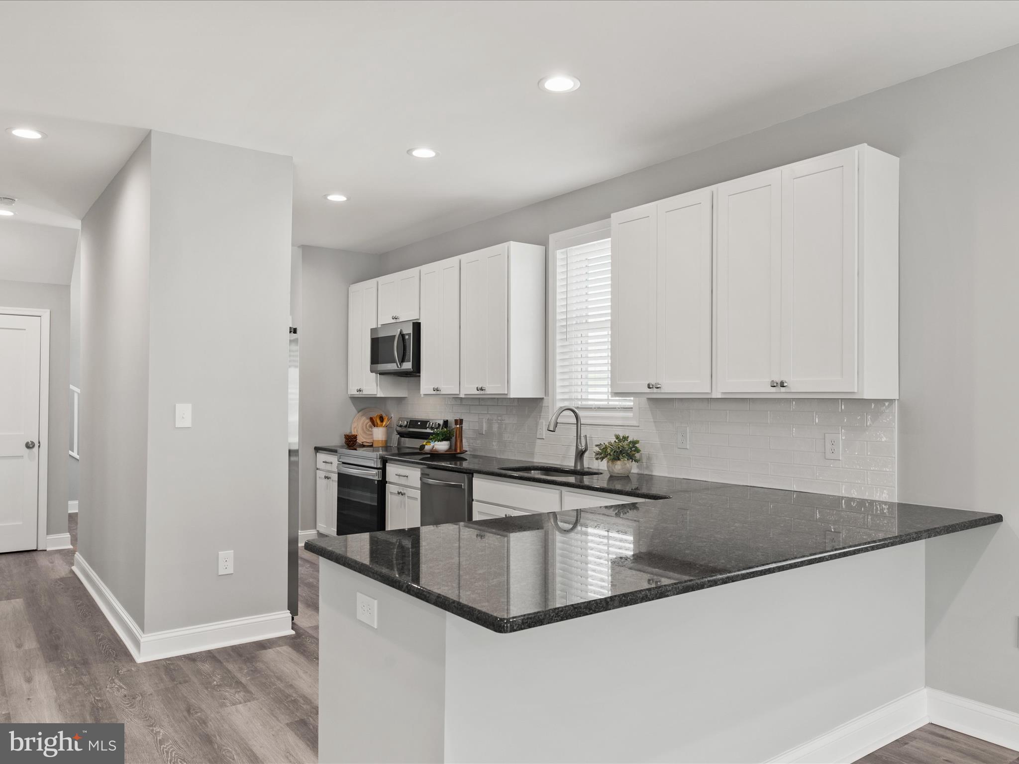 36986 Blue Teal Road Selbyville, DE 19975 - Photo 14 of 54 a kitchen with stainless steel appliances granite countertop a sink a stove and a refrigerator