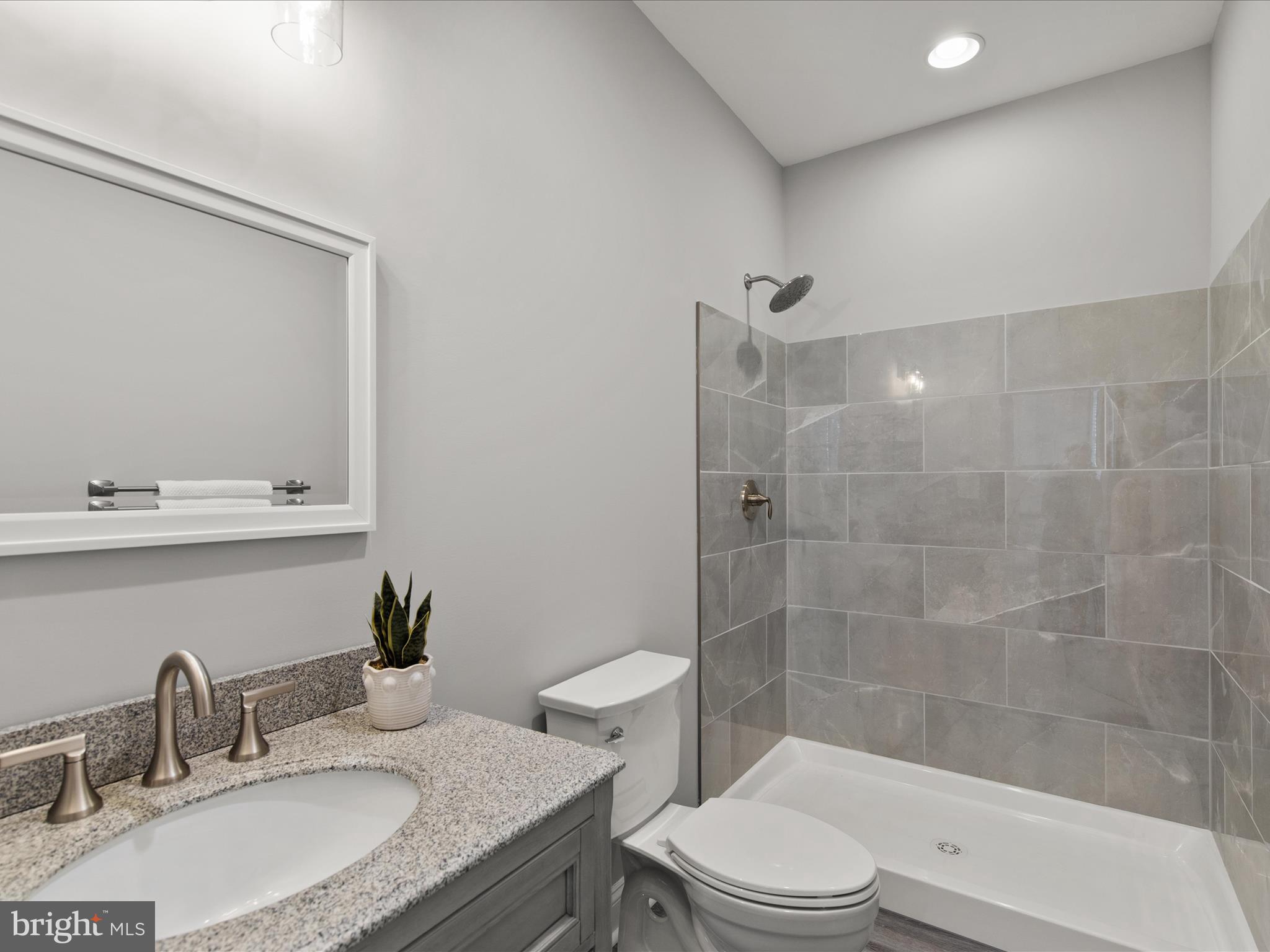 36986 Blue Teal Road Selbyville, DE 19975 - Photo 27 of 54 a bathroom with a granite countertop sink toilet a mirror and shower