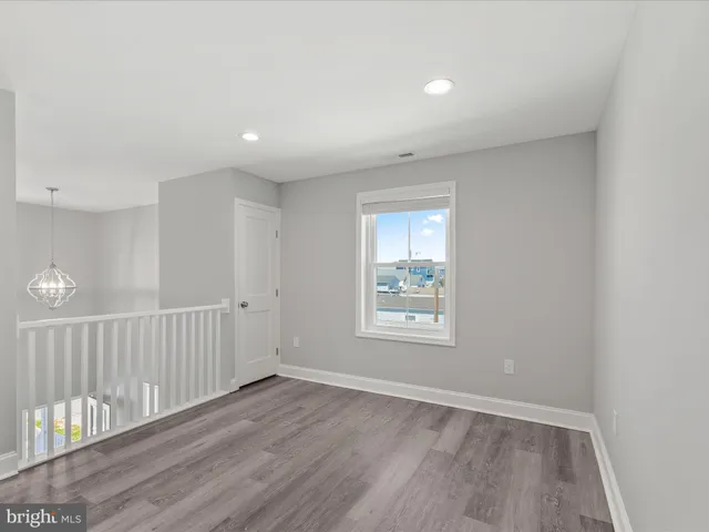 a view of an empty room with a window and a kitchen