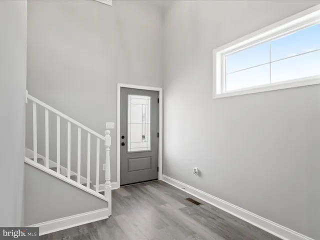 a view of a hallway with wooden floor and entryway