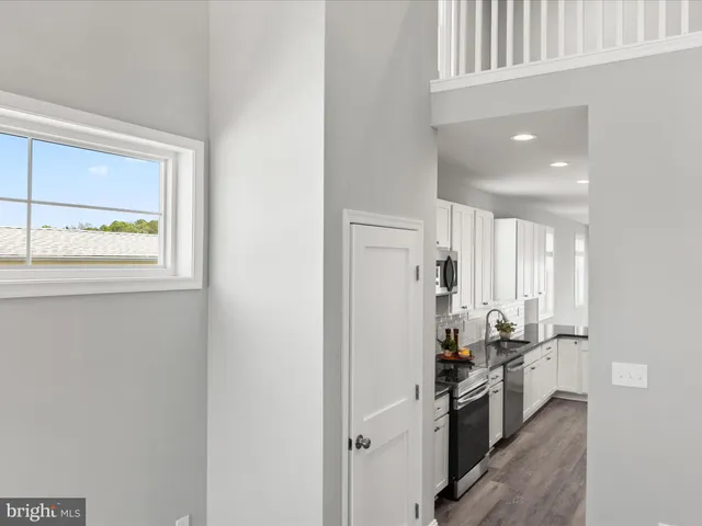 a kitchen with stainless steel appliances granite countertop a refrigerator a stove and a wooden floors