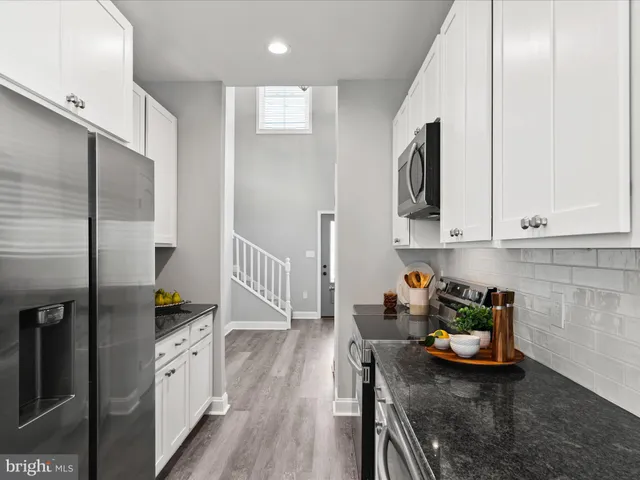 a kitchen with stainless steel appliances a sink a stove a microwave cabinets and a counter space