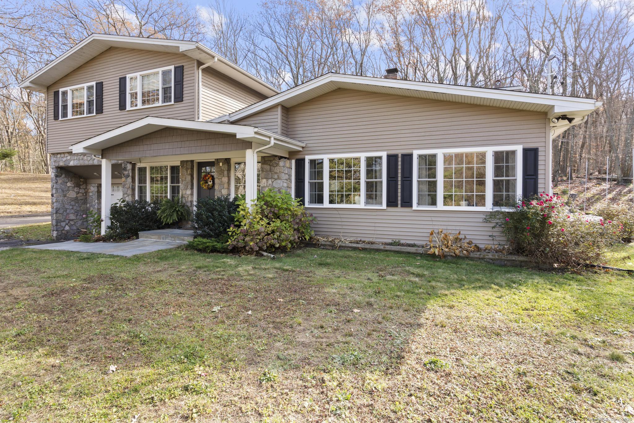 115 Old Wolcott Road Bristol, CT 06010 - Photo 3 of 23 a view of a brick house with a yard plants and large trees