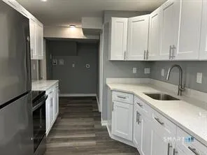 a kitchen with white cabinets and sink