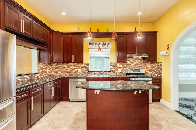a kitchen with stainless steel appliances granite countertop a stove a sink and a microwave